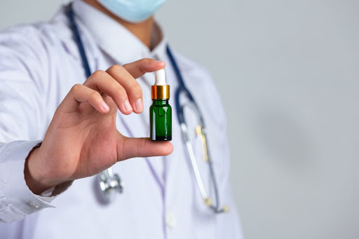lekár drží v ruke fľašku CBD oleja