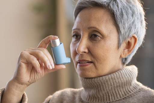 staršia žena drží inhalátor proti astme